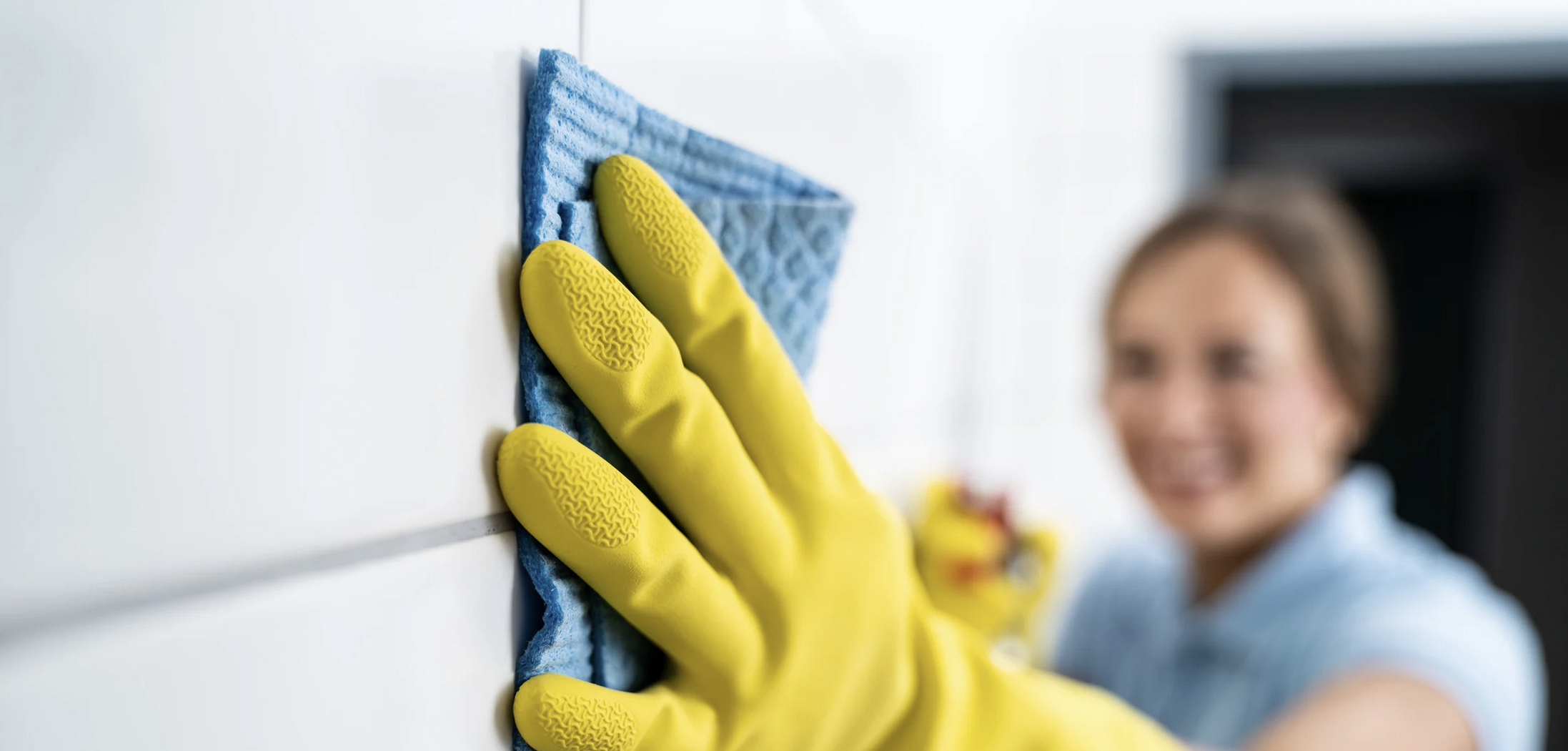 Person cleaning bathroom tiles